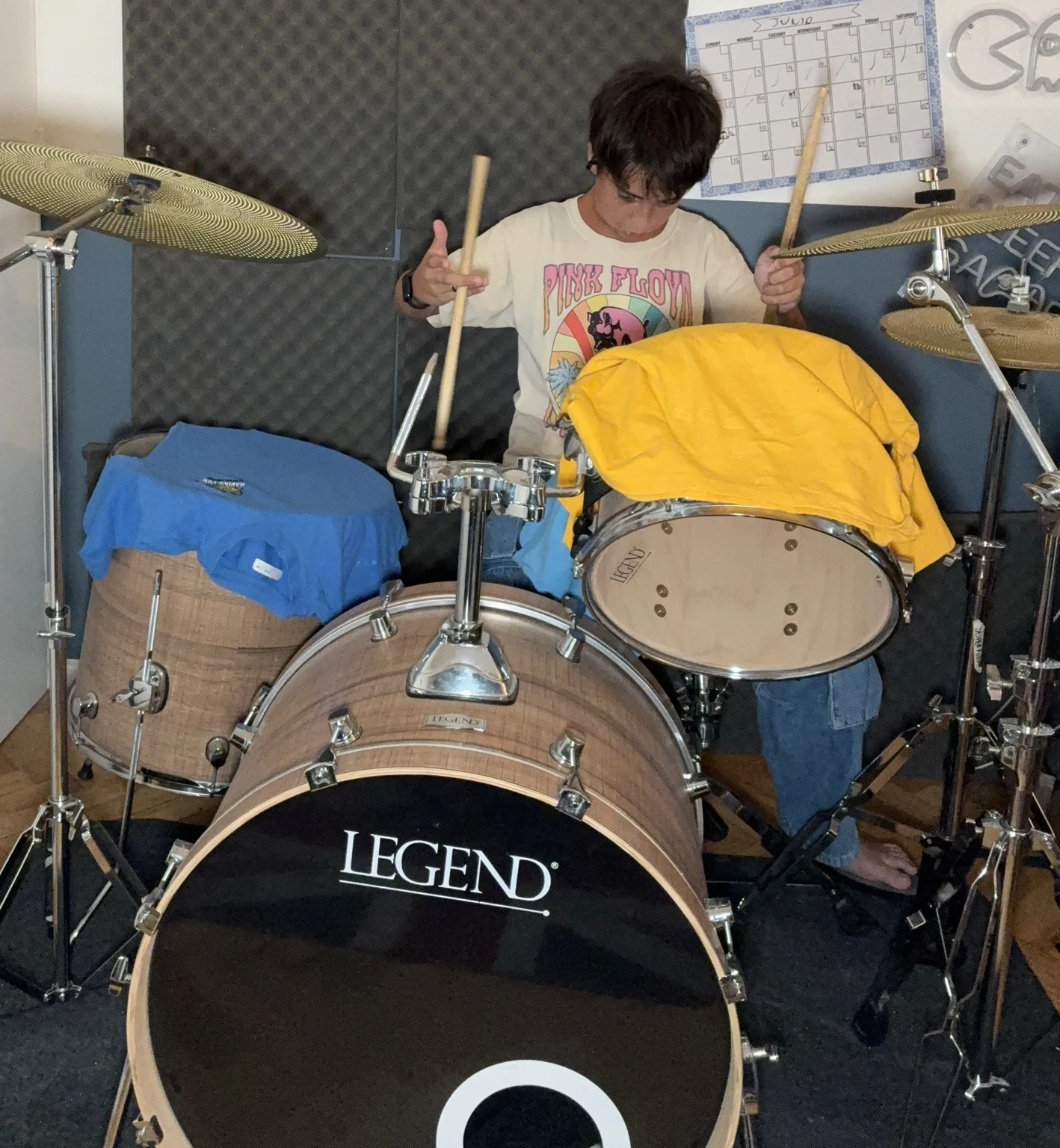 Jasper sentado detrás de una batería acústica con sus baquetas